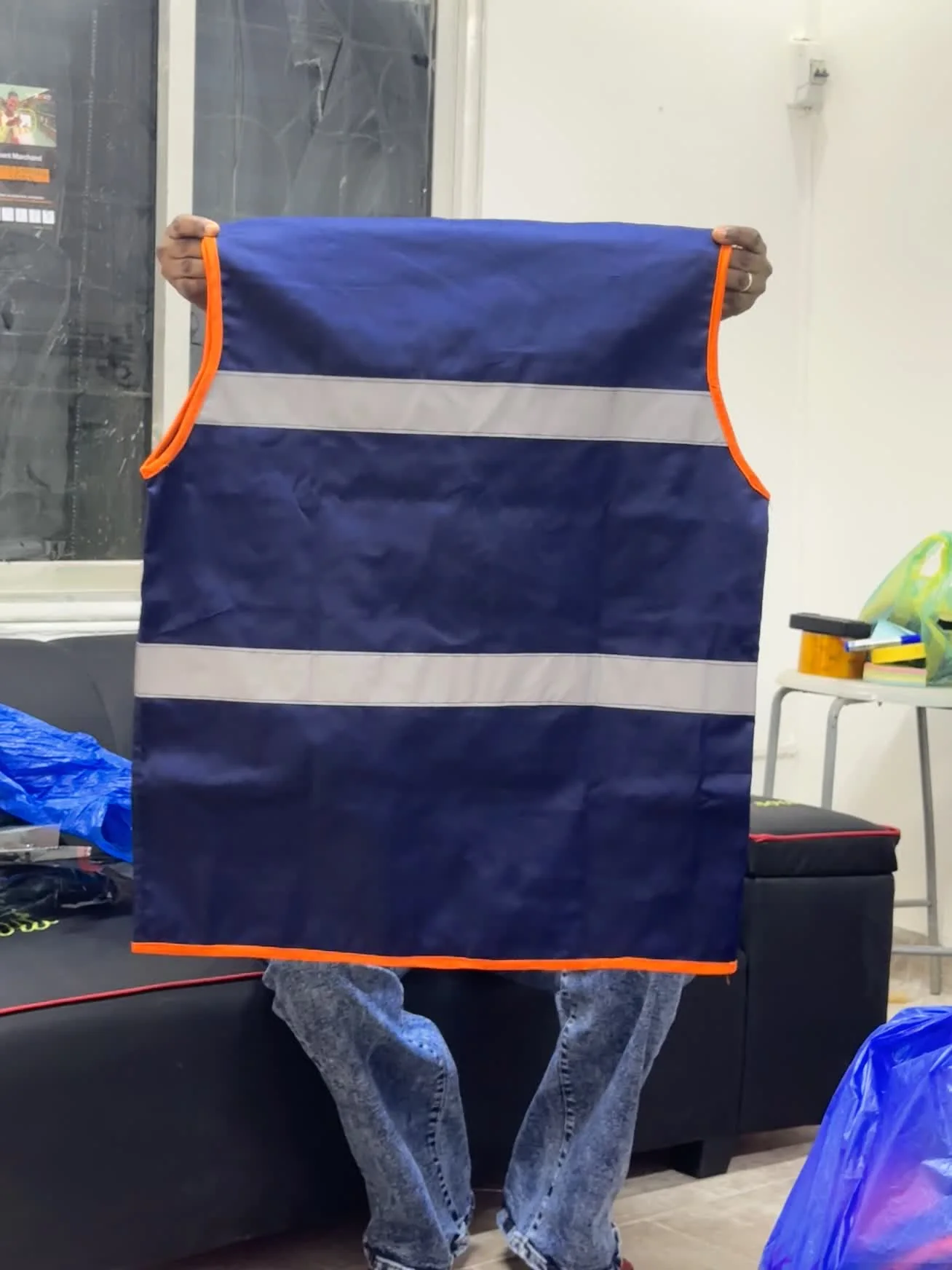 Dos d’un gilet de chantier bleu marine à bandes réfléchissantes